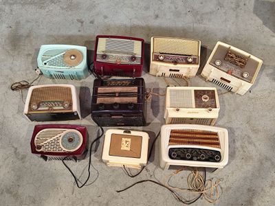 a lot of old radio ' s that are sitting on the floor