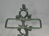 a metal cross with a bird on it on a table