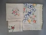 three vintage handkerchiefs with embroidered flowers on them on a table