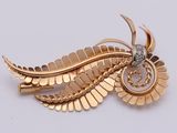 an image of a gold brooch with a bird on it ' s back