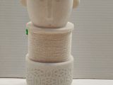 three white vases stacked on top of each other on a table