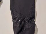 a black dress with lace on it hanging on a wall
