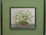 tableau représentant un vase de fleurs dans un cadre vert accroché au mur
