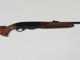 un fusil posé sur une table devant un fond blanc