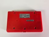 a red plastic box with a label on it on a white surface