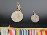 two medals and a medal are on display on a black surface