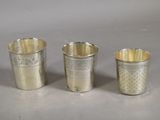 three silver cups sitting next to each other on top of a table