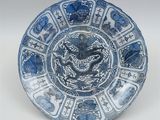 blue and white plate with a dragon on the center