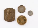trois pièces et une médaille sont posées sur une surface blanche