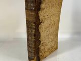 an old book sitting on top of a table next to a white wall