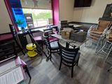 tables and chairs in a restaurant with a tv in the background