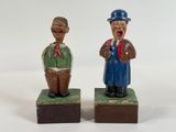 two figurines of two men standing on blocks