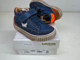 des chaussures de petit garçon bleues et orange posées sur une boîte blanche