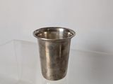 a small silver cup sitting on a clear table