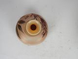 a small vase with a flower on it sitting on a table