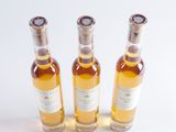 three bottles of wine sitting next to each other on a white surface