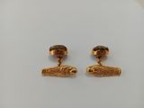 a pair of gold plated earrings with a fish on it