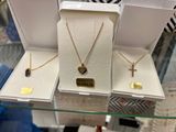 two necklaces and a cross are on display in a jewelry store
