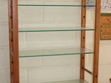 a display case with glass shelves in the corner of a room