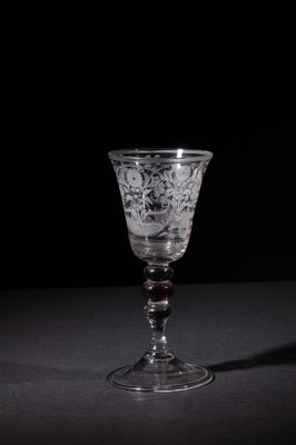 a wine glass sitting on a table with a black background