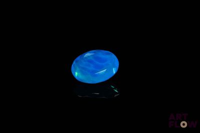 une image représentant un anneau bleu dans l'obscurité, avec un reflet à la surface