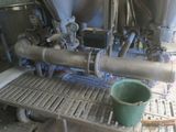 a green bucket sitting on top of a table next to a machine
