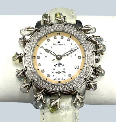 un gros plan d'une montre-bracelet posée sur un anneau blanc
