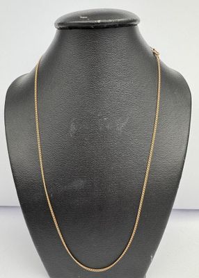 a black mannequin with a gold chain on it