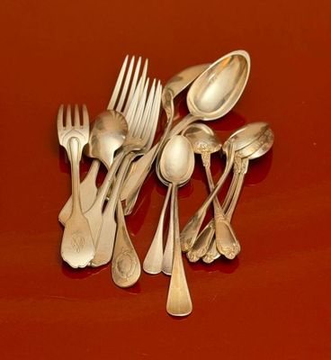 a lot of silver spoons and forks on a red surface