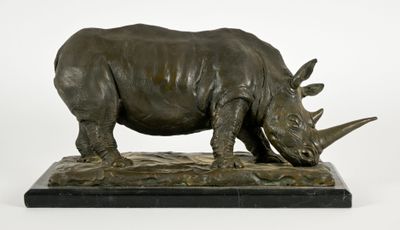 statue d'un rhinocéros posée sur un socle en marbre, sur fond blanc