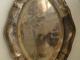 a silver plate on the wall next to a vase