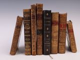 several old books stacked on top of each other on a white surface