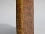 un vieux livre posé sur une table à côté d'un fond blanc