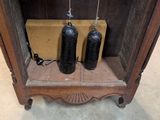 two black bottles sitting on a shelf in a room
