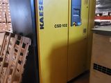 a machine that is sitting in a warehouse with pallets of wood