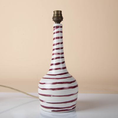 a red and white striped lamp on a white table