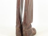 pair of brown leather boots sitting on top of a white surface