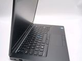 a black laptop with a blue keyboard on a white surface
