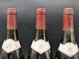 three bottles of wine are lined up on a black surface
