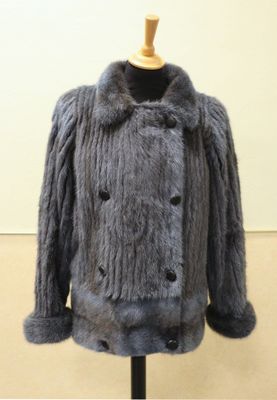 grey fur coat on a mannequin stand in a room
