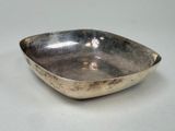 a silver bowl on a table with a white background