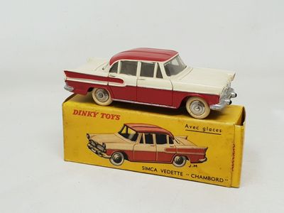 a red and white toy car sitting on top of a box