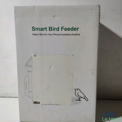 une boîte blanche ornée d'un oiseau, posée sur une table