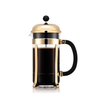 une cafetière à piston dorée et noire sur fond blanc