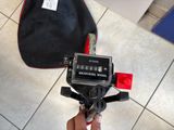 a person holding a camera and a bag on the floor