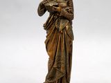 a bronze statue of a woman holding a book in her hands