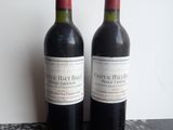 two bottles of red wine sitting on a table