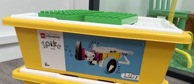 a yellow toy box with legos on top of it
