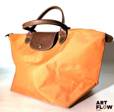 un sac orange muni d'une poignée marron posé sur une table