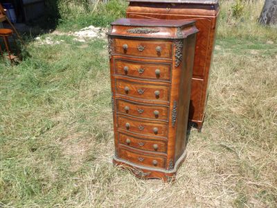 une commode en bois posée dans l'herbe